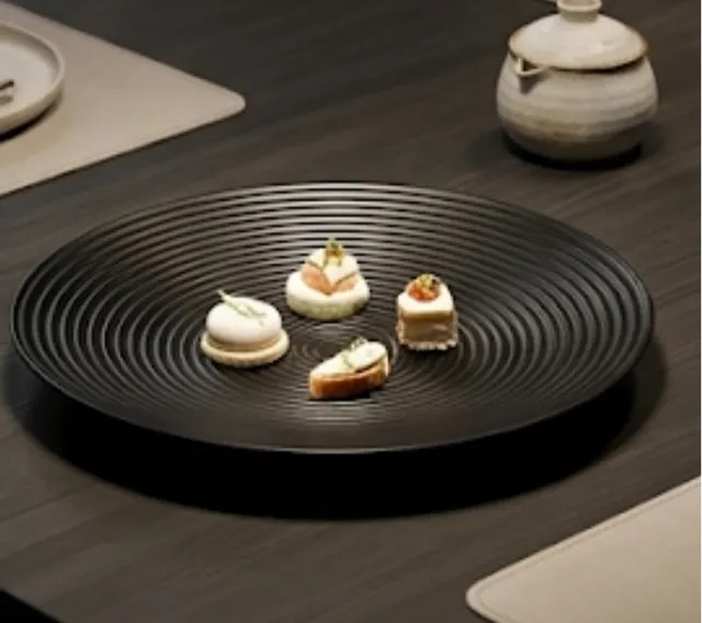 Assiette noire motifs cercles sur pied central - Élégance décorative graphique